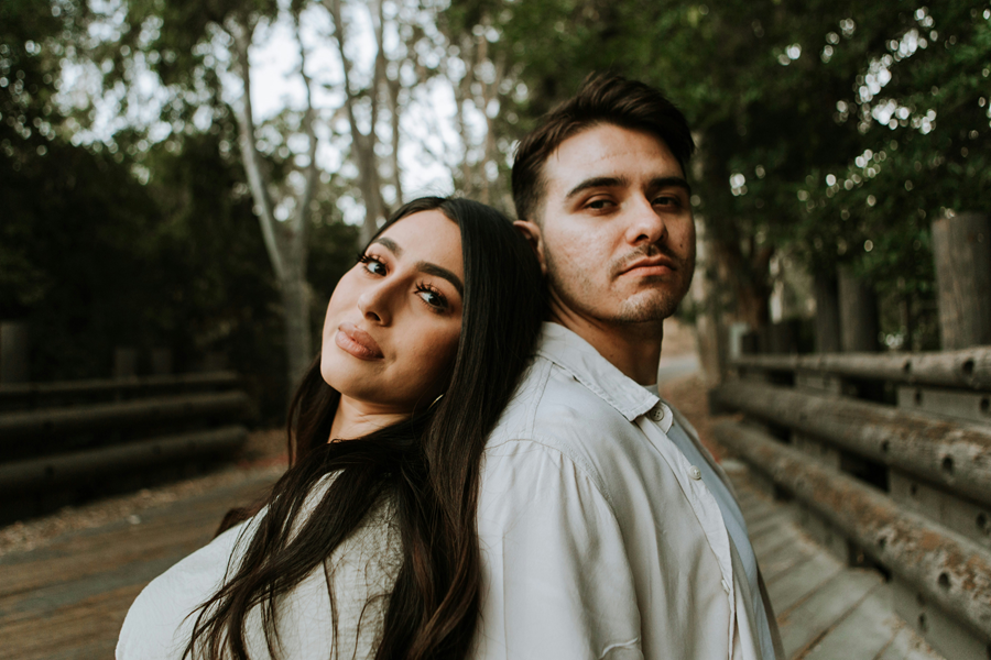 A smart latino money couple looks on while feeling confident about their personal finances.